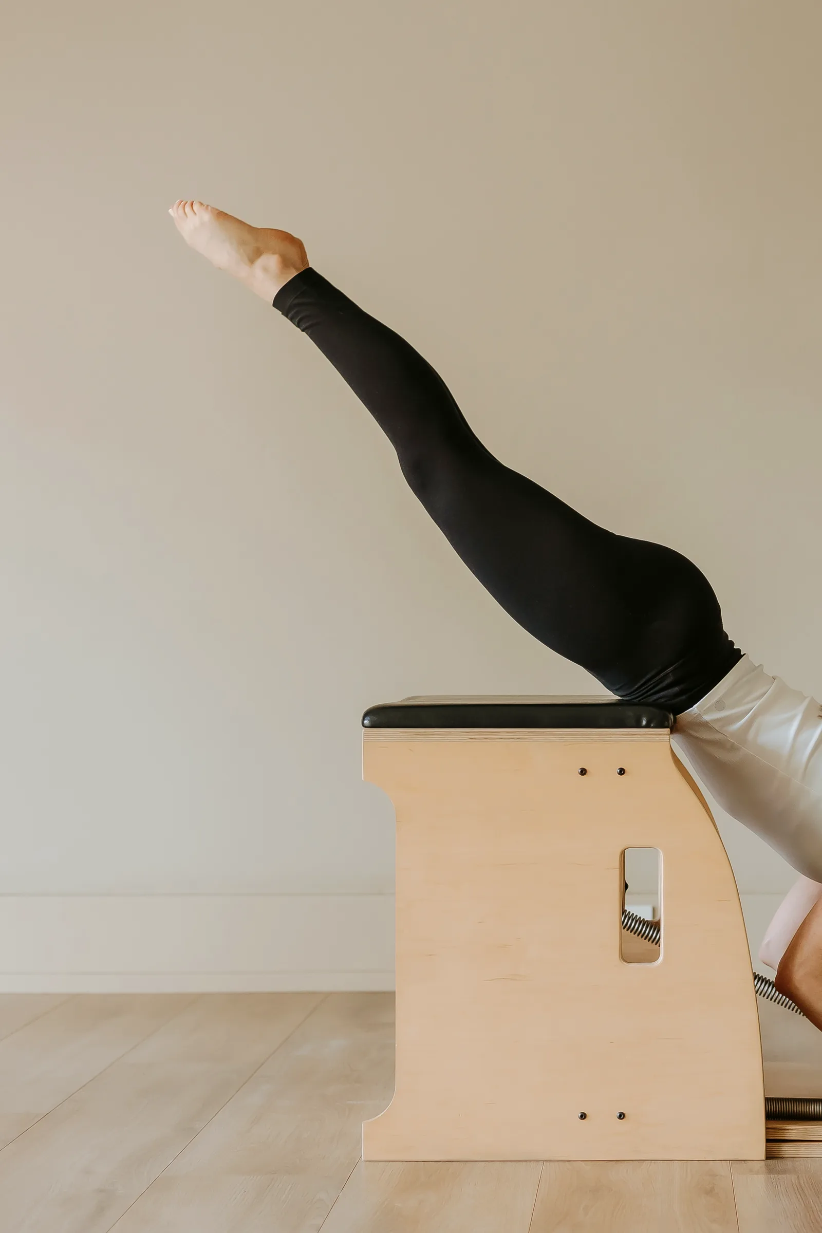 Legs extended overhead on a Pilates chair at Siân Collins Pilates, Saxonwold