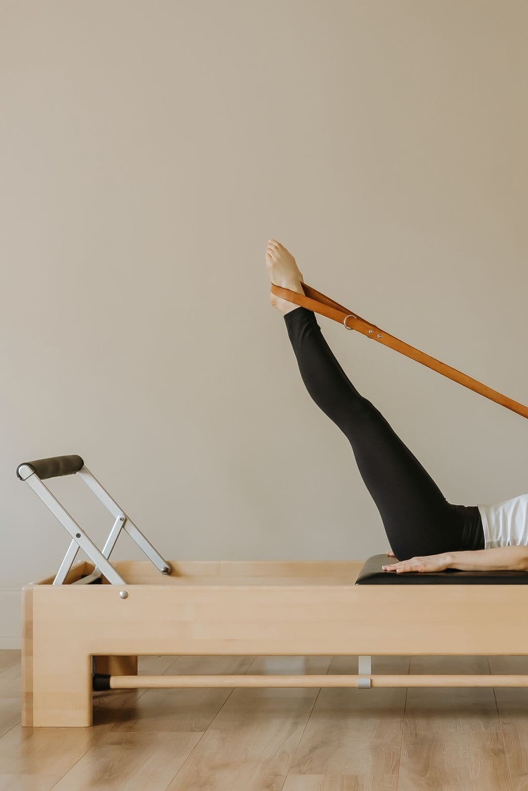 Siân lying on the reformer with long legs extended in the straps